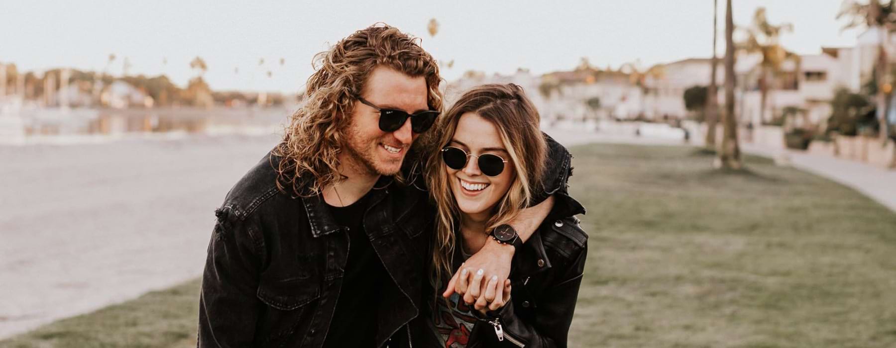 a couple walks on grassy area in open neighborhood lot